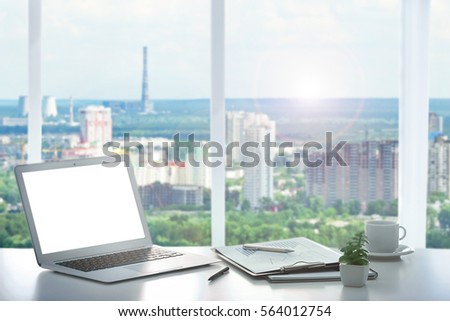  Modern technology concept. Laptop on table and cityscape view through window