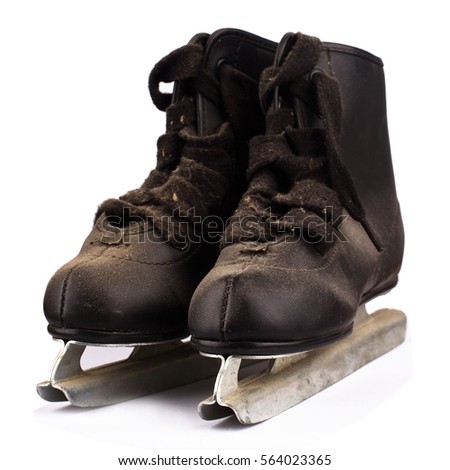 front view of a pair of small children black ice skates covered in dust isolated on white background