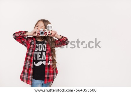 Girl taking picture with a retro camera isolated on white