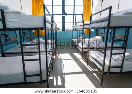 Morning inside the hostel bedroom with clean white beds for students and lonely young tourists Royalty-Free Stock Photo #564055135