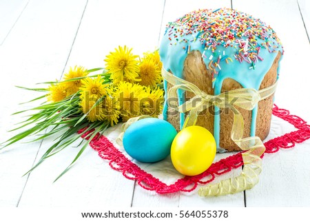 Traditional Easter treats: Easter cake and colorful easter eggs on white wooden table