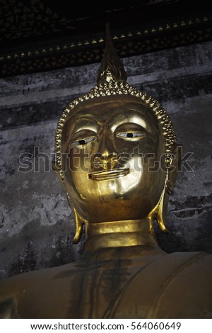 close up face of bronze buddha statue at Bangkok temple in Thailand in Asian culture and religion concept sitting