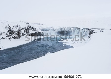 Winter Godafoss waterfall covered in snow and partly frozen, Iceland