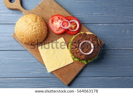 Delicious cheeseburger on wooden background