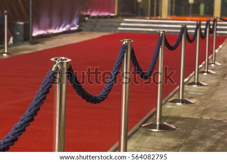 Long red carpet between rope barriers on entrance. Royalty-Free Stock Photo #564082795