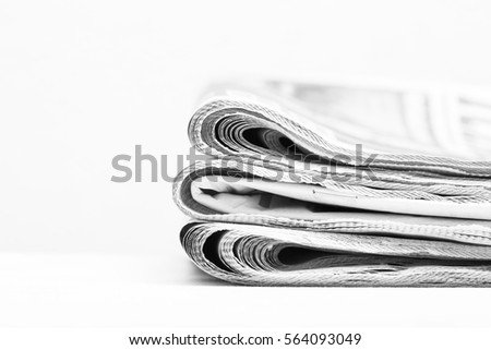 Newspapers. Stack of newspapers. The pile of news are on a white surface. Image in black and white.