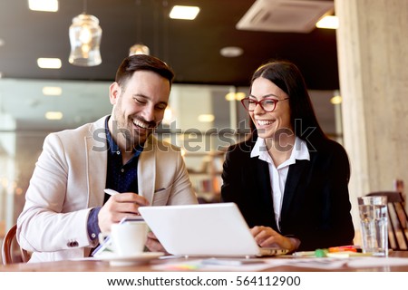 Two young businessman having a successful meeting at restaurant. Royalty-Free Stock Photo #564112900