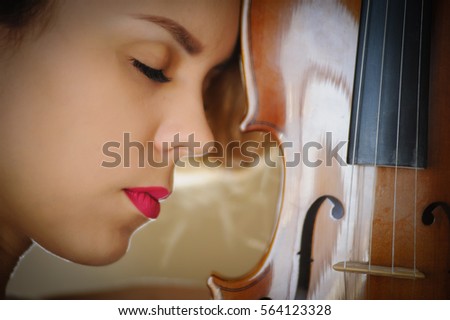Music portrait of young woman. Violin play. Close up face beautiful model