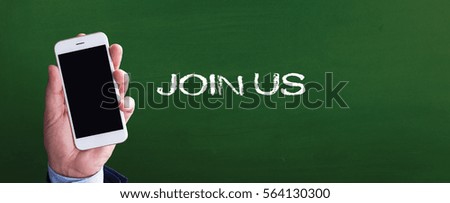 Smart phone in hand front of blackboard and written JOIN US