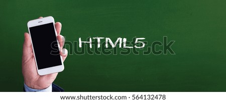 Smart phone in hand front of blackboard and written HTML5