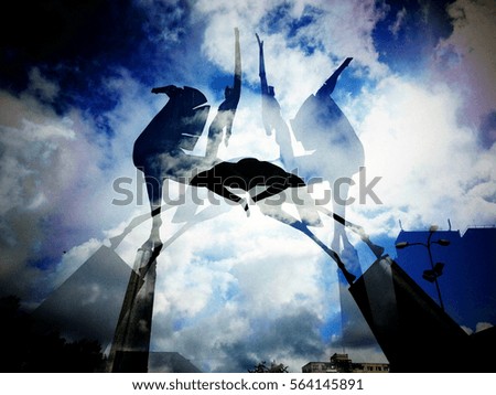 Double exposure of horse and rider monument with cloudy sky