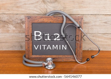Medical concept - stethoscope and blackboard with text "Vitamin B12" on wooden background Royalty-Free Stock Photo #564146077
