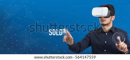 Future Technology and Business Concept: The Man with Glasses of Virtual Reality and touching SOLD button