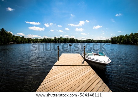 Lake Dock with Boat Royalty-Free Stock Photo #564148111