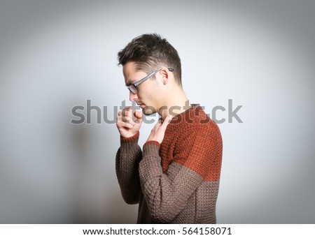 Handsome man coughs, wearing glasses, isolated on background