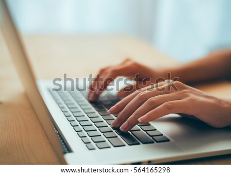 Woman hands typing on laptop keyboard at the office, Woman worker and business concept, Soft focus on vintage wooden table. Royalty-Free Stock Photo #564165298