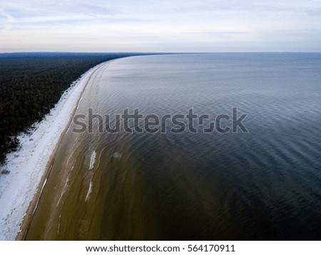 aerial view of frozen beach in winter. drone photography. sea with waves.