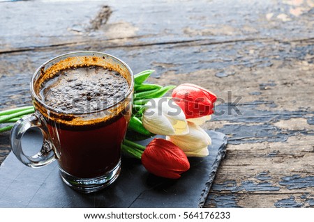 Cup of coffee with spring flowers on wooden background with copyspace