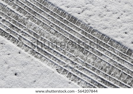 Snow tyre tracks - snowy winter road surface background.