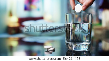 In a bedroom before going to sleep, an effervescent tablet is made to dissolve in a glass of water. Concept: vitamin, medicine, care of your body.