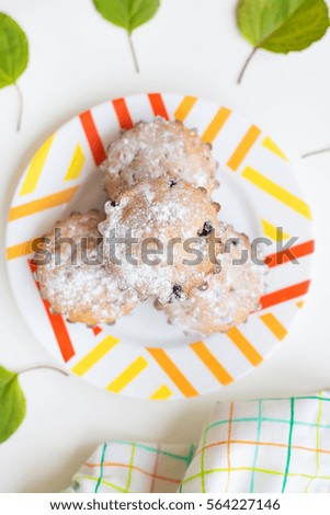 colored cupcakes on a plate with green leaves and towel