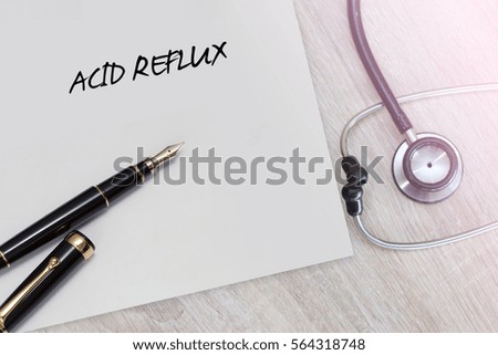 Acid Reflux word with stethoscope and pen on wooden background as medical concept
