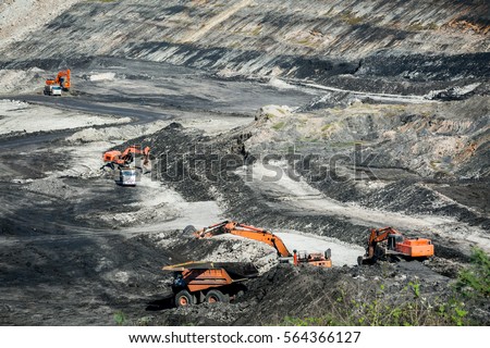 Mining dump trucks working in coalmine , Used as a source of electricity generation in the country. Royalty-Free Stock Photo #564366127