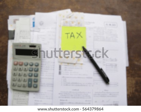 Tax form with money, pen, calculator and clock, abstract blur background