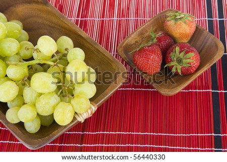 strawberries and grapes in a wooden tray