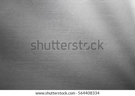 Close up industrial background of fractally scratched diagonal circular lines to silver metal/stainless steel surface. Creative lighting detail macro photography.