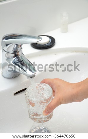 Filling a glass with water under the tap