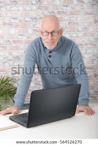 Portrait of a handsome mature man using laptop at office