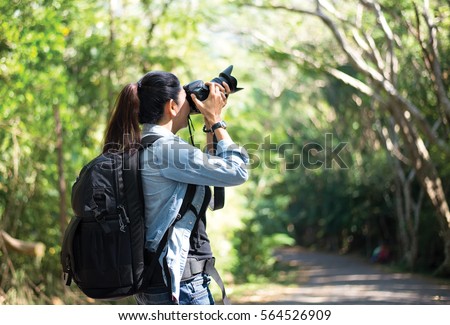 Professional woman photographer taking camera outdoor portraits with prime lens in the photography nature. Greenery tone 2017.  Travel and Lifestyle Concept