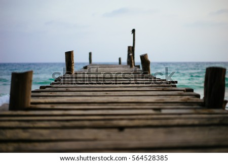A wooden bridge extends into the sea.