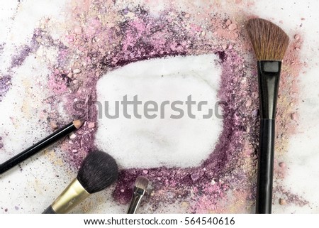 Makeup brushes and pencil on white marble background, with traces of powder and blush forming a frame. A horizontal template for a makeup artist's business card or flyer design, with copy space