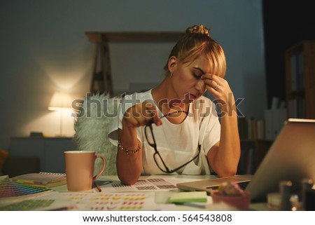 Exhausted graphic designer having headache after long day of work
