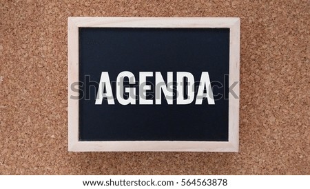 Business Concept - Chalk board with inscription agenda on a wooden table.


