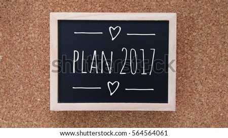 Business Concept - Chalk board with inscription plan 2017 on a wooden table.

