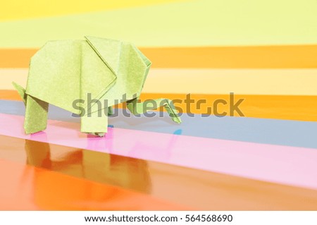 Paper origami elephant isolated on a colorful background