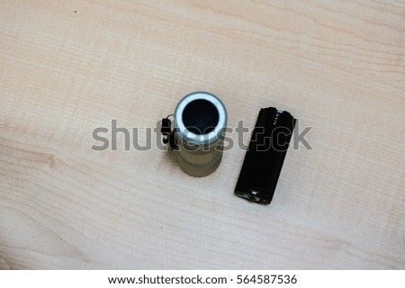 Mini silver flashlight on the wooden floor