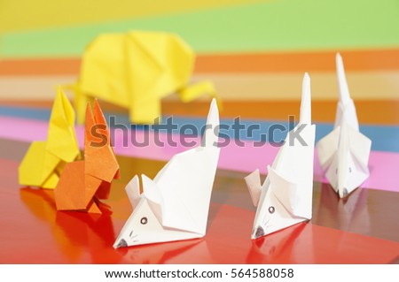 Paper origami animals isolated on a colorful background