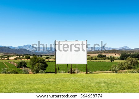 Big blank billboard in a nice scenery along the Garden Route of South Africa. The billboard is hand made, you can see the various boards and screws that could still shine through the image you place