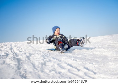 Boy is having fun on snow, sledding