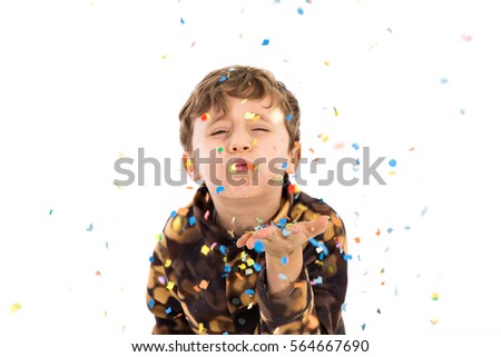 boy blowing confetti from his hand