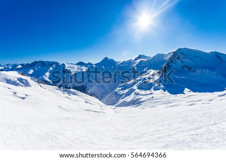 Panoramic view over empty slope and valley in the background, snow and sun, winter picture of Samnaun, Swiss Alps, Switzerland, Europe.
