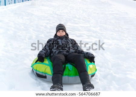 Teenager sitting on a green tubing