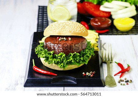  Delicious grilled beef burger, large massive thick classic burger with french fries,vegetables,soda drink and fresh bread on white wooden background.Copy space,Top view..