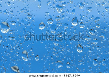 Selective focus of water droops on the glass with blue background