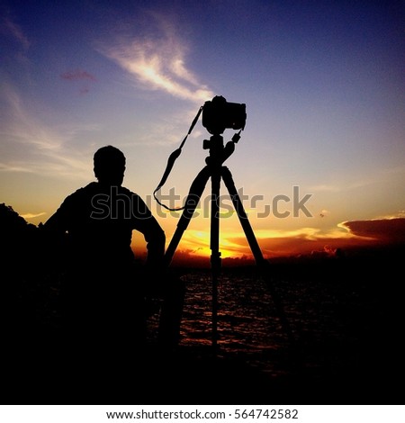photographer take time lapse with digital camera on tripod