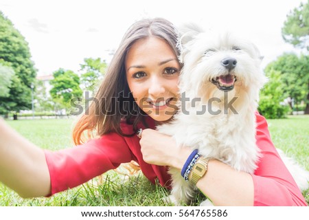 Beatiful girl taking a selfie with a dog in the park